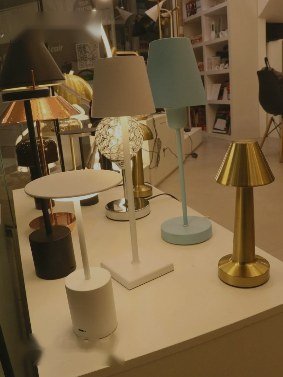 Luminárias de mesa em várias cores e acabamentos expostas na loja